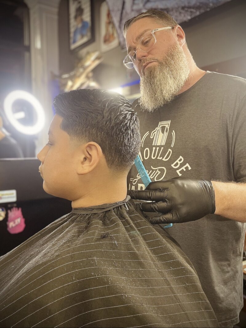 Eric the Barber comb in hand, finishing the neckline on a client's fresh haircut